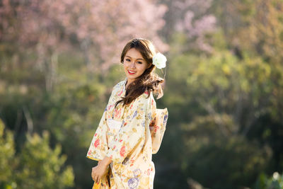 Portrait of smiling young woman standing outdoors