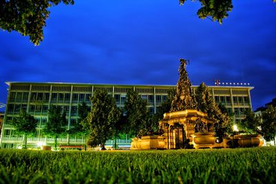 Illuminated temple against blue sky at night