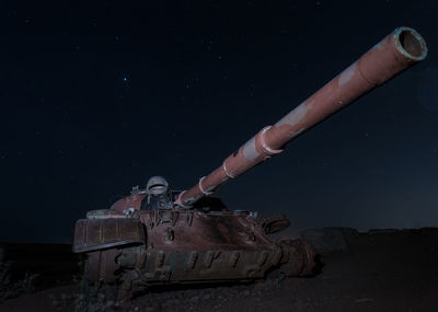 Low angle view of hand on abandoned building against sky at night