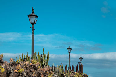 Street light by sea against blue sky