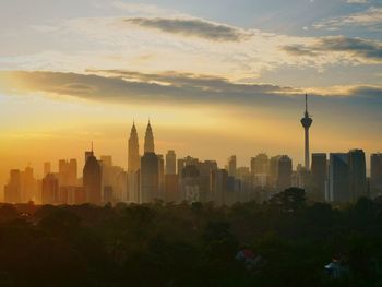 Buildings in city against sky during sunrise 