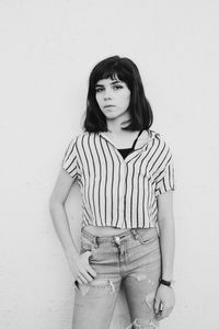 Portrait of woman standing against wall