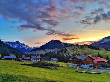 Houses by mountains against sky during sunset