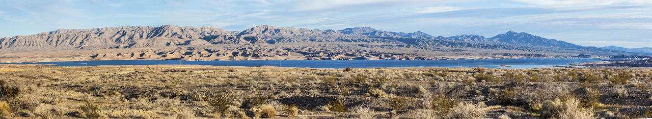 Scenic view of sea and mountains against sky