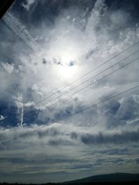 Low angle view of power lines against cloudy sky