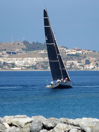 Sailboat sailing on sea against sky