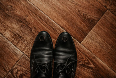 Low section of man standing on hardwood floor