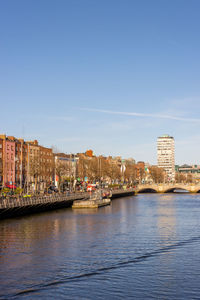 Bridge over river against buildings in city