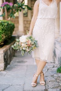 Low section of woman standing on footpath