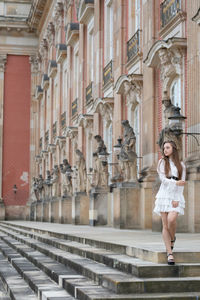 Full length of a young woman standing in city