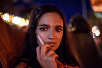 Portrait of young woman smoking cigarette