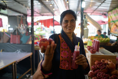 Portrait of smiling woman standing at store