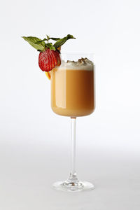 Close-up of drink on table against white background