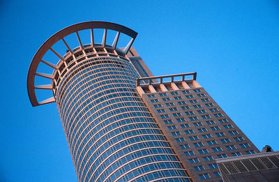 Low angle view of skyscraper against clear blue sky