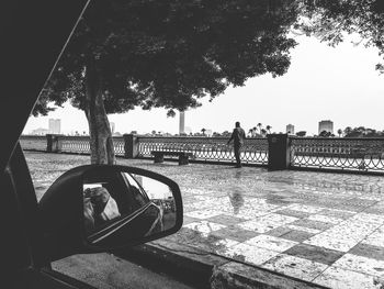 Man and woman by river in city against sky
