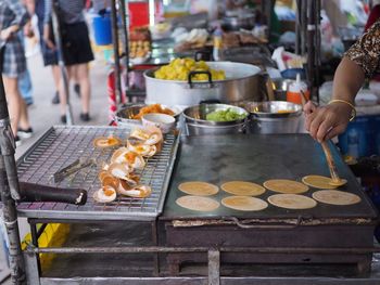 Person preparing food at market stall