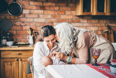 Side view of young woman using mobile phone while sitting at home