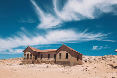 Built structure on beach against blue sky