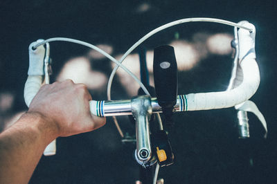 Cropped image of man holding bicycle handlebar on road