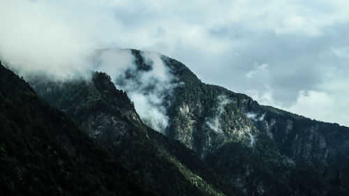 Scenic view of mountains against cloudy sky