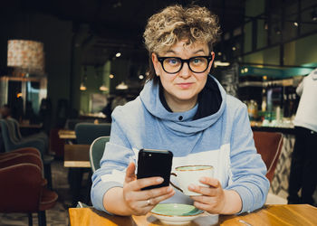 Stylish woman casual wear portrait in public cafe - working with mobile