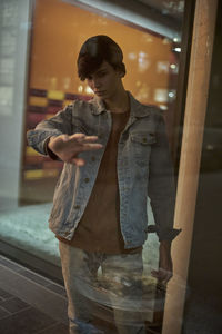 Young man against window