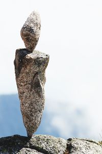 Close-up of stone stack on rock against sky