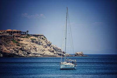 Sailboat sailing on sea against sky