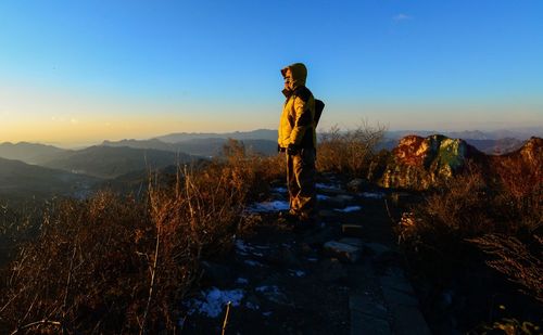 Man standing on mountain against clear sky