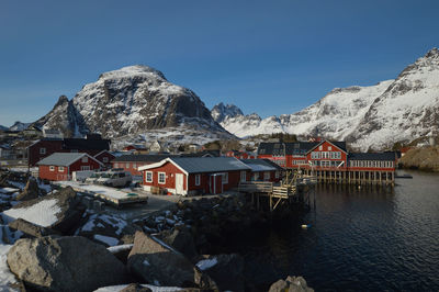 Houses by snowcapped mountains against sky