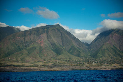 Scenic view of sea and mountains against sky