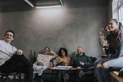 Happy multiracial entrepreneurs taking break after work at creative workplace