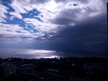 Aerial view of city by sea against sky