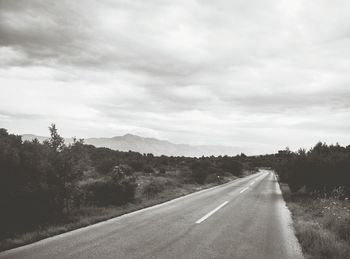 Surface level of country road against cloudy sky