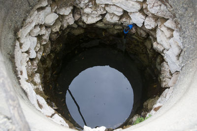 Directly below shot of stone wall with hole