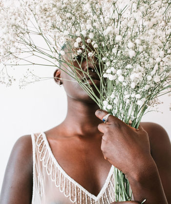 MIDSECTION OF WOMAN AGAINST PINK FLOWERING PLANTS