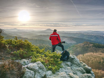 Rear view of man on mountain against sky