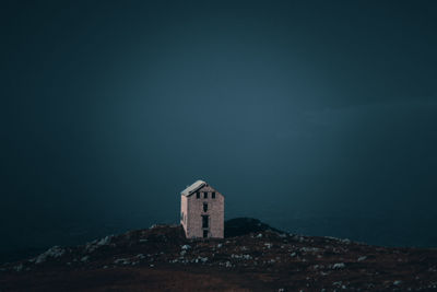 Tower amidst sea and buildings against sky