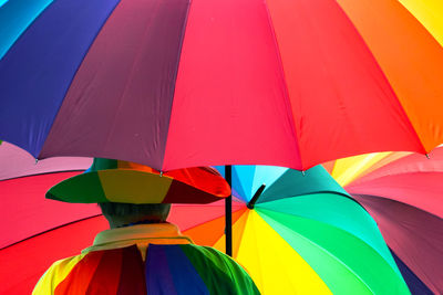 Rear view of man with colorful umbrellas while standing outdoors