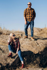 Full length of young couple against clear sky