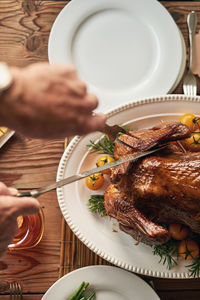 Cropped hand of person preparing food on table