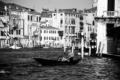 Boats in canal amidst buildings in city