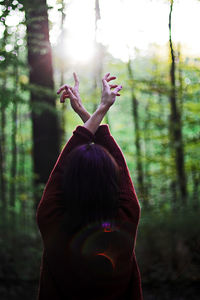 Woman with tree trunk in forest