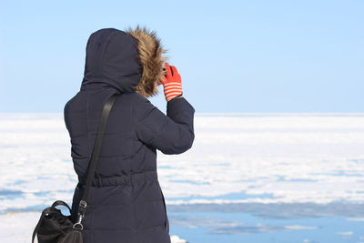 Side view of woman standing on snow covered land