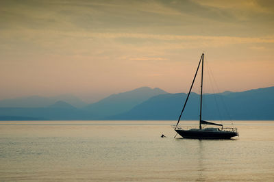 Sailboat on sea against sky during sunset