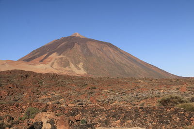 View of volcanic mountain against blue sky