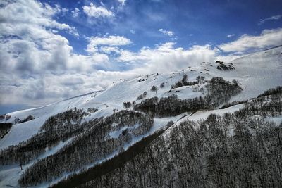 Scenic view of snow covered mountains against sky