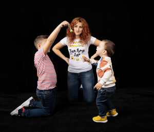 Rear view of people with toy against black background