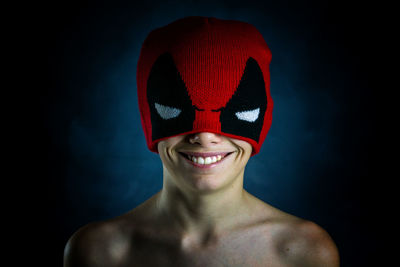 Portrait of a smiling young man against black background