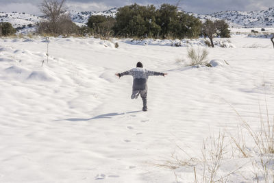 Boy running and enjoying the snowy landscape,